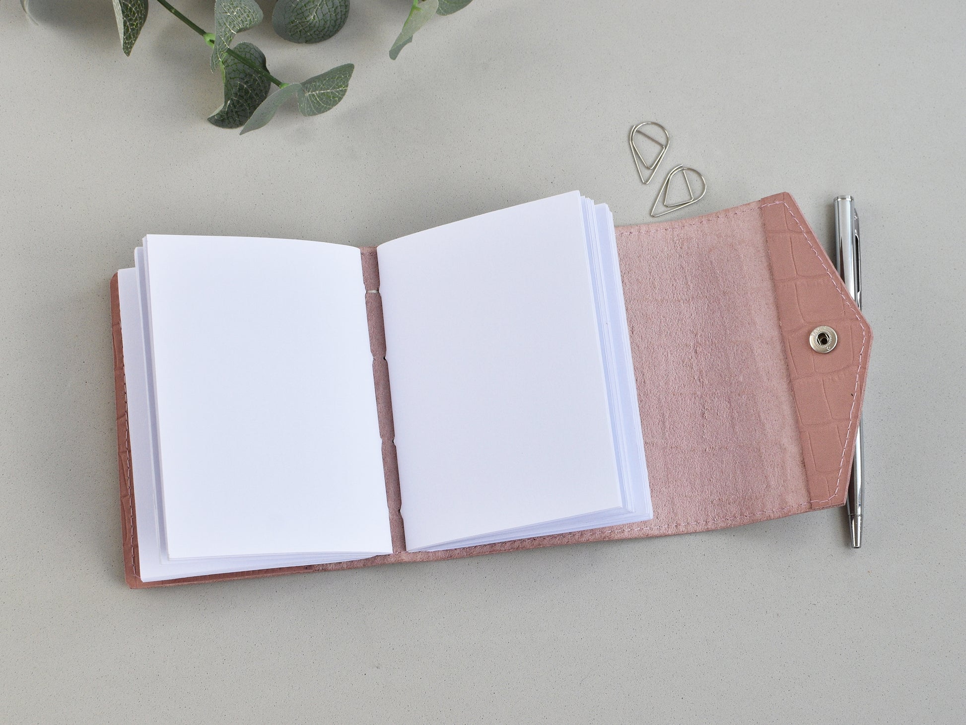 Opened leather journal wit a blank pages