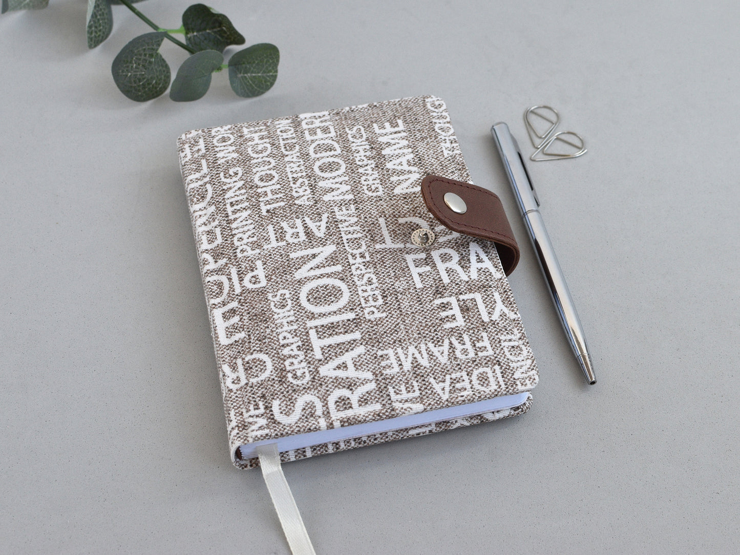 fabric notebook with closure, shown on the desk
