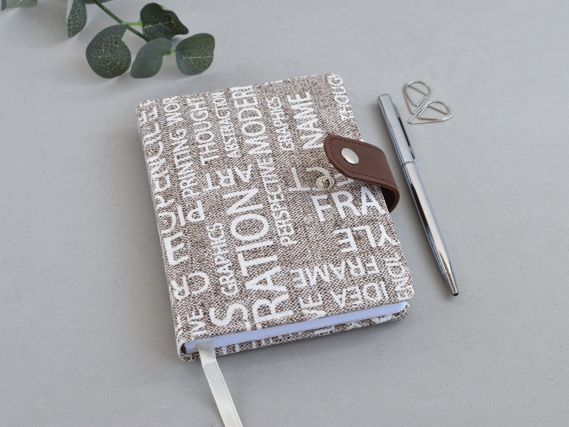 fabric notebook with closure, shown on the desk