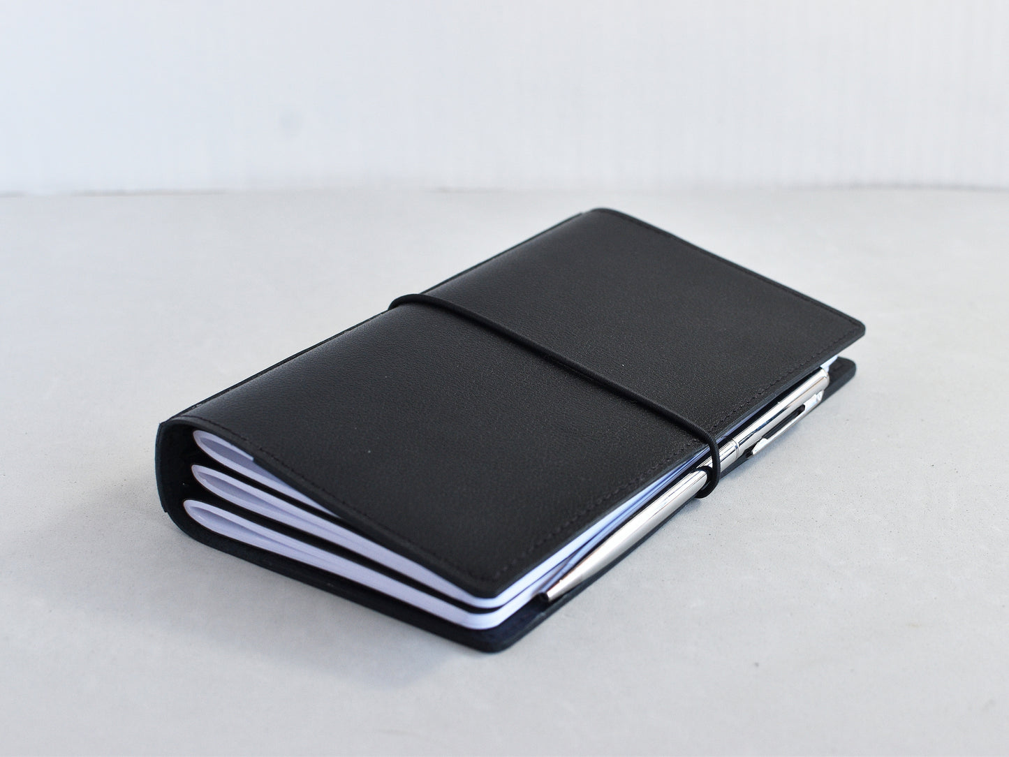 Black travel journal and silver pen