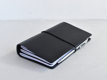 Black travel journal and silver pen