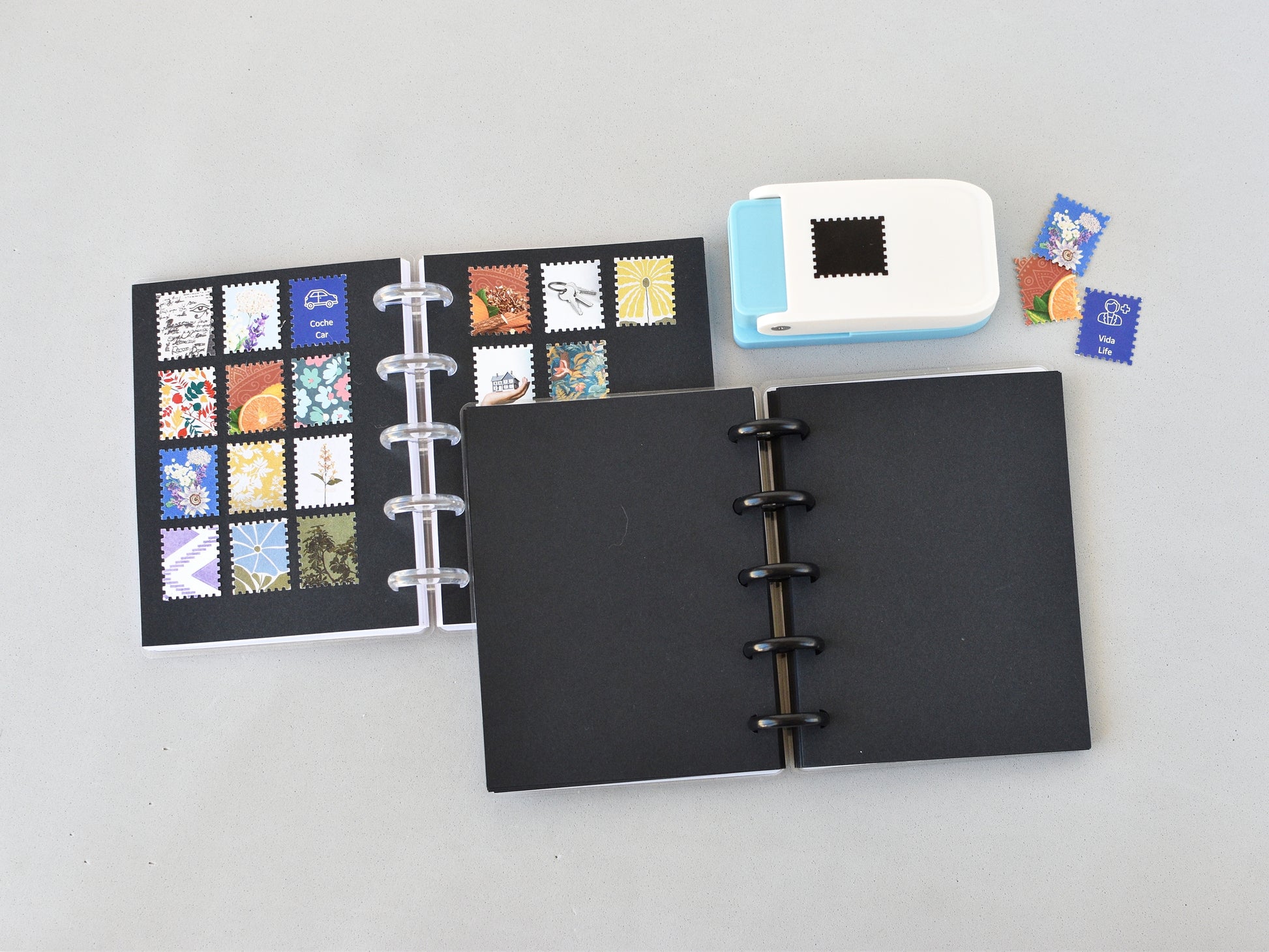 Black disc-bound notebook with colorful stamp designs on a gray background