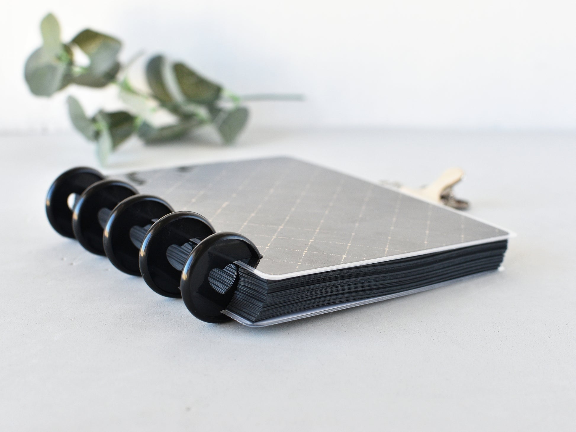 Black paper notebook with black discs on a light surface